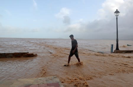 A boy walks along the beach after heavy rains in Los Alcazeres