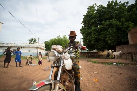 Local activist and would-be migrant Moussa Kebe poses for a photo on his motorcycle in Goudiry, Senegal, September 5, 2016. REUTERS/Mikal McAllister