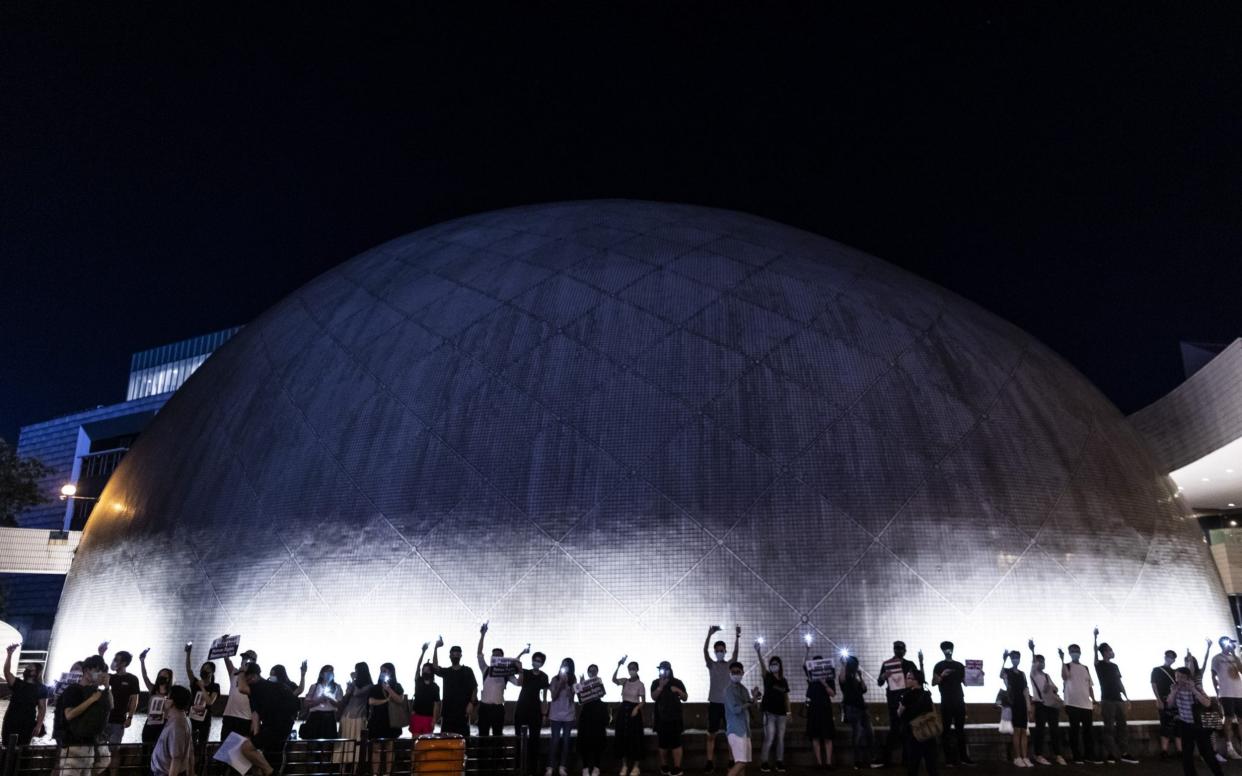 Demonstrators shine lights from their smartphones as they form a human chain in front of the Space Museum during the Hong Kong Way event  - Bloomberg