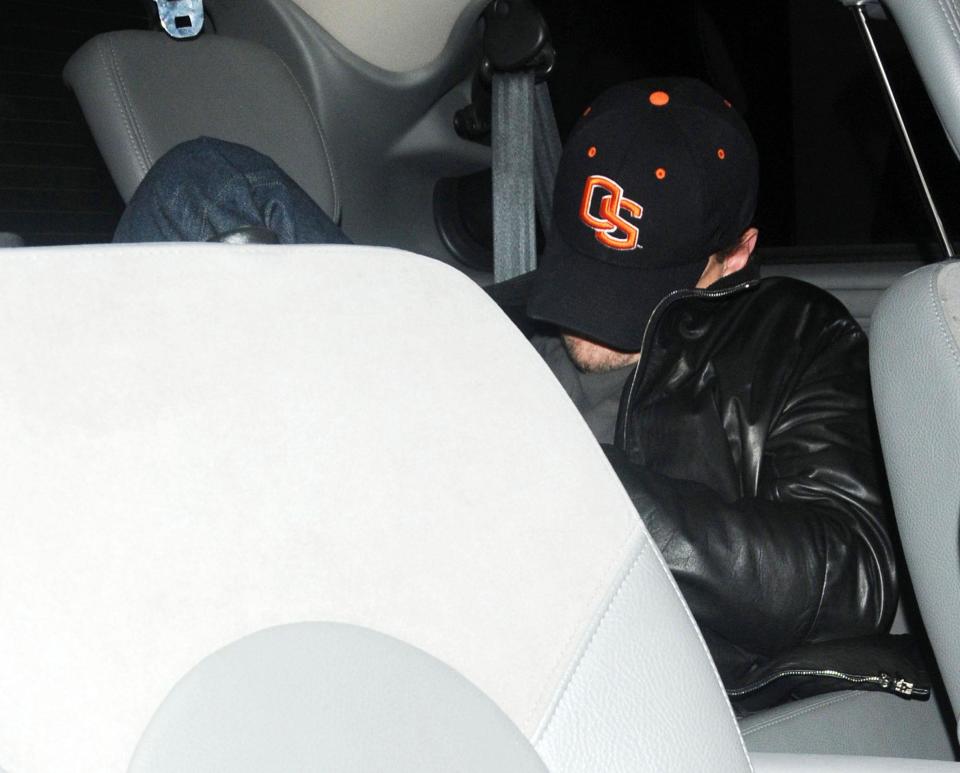 Leo DiCaprio hides under his hat leaving a nightclub. (Photo: Getty Images)