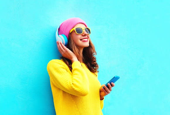 A young woman streaming music from her smartphone.