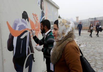 Afghan Artlords paint a message on a wall at the American University of Afghanistan in Kabul, February 14, 2018. REUTERS/Omar Sobhani