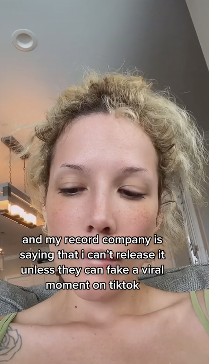 Closeup of Halsey on TikTok with text that reads, "and my record company is saying that i can't release it unless they can fake a viral moment on tiktok"