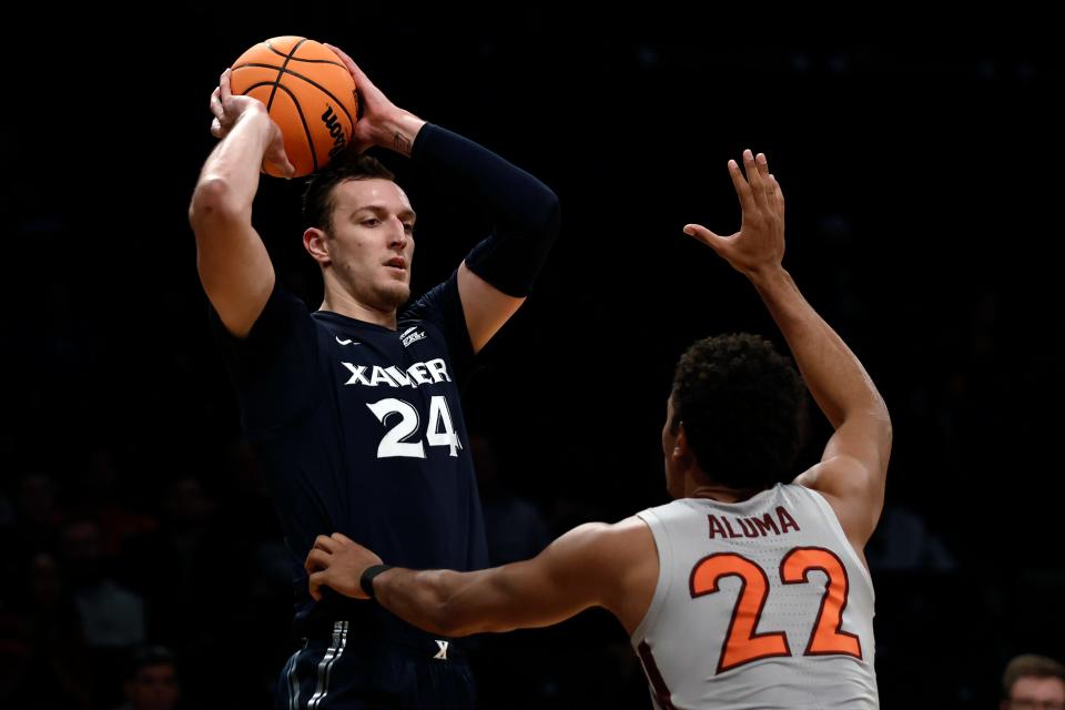 Xavier's Jack Nunge (24) looks to pass over Virginia Tech's Keve Aluma (22) during the first half of an NCAA college basketball game in the NIT Season Tip-Off tournament Friday, Nov. 26, 2021, in New York. (AP Photo/Adam Hunger)