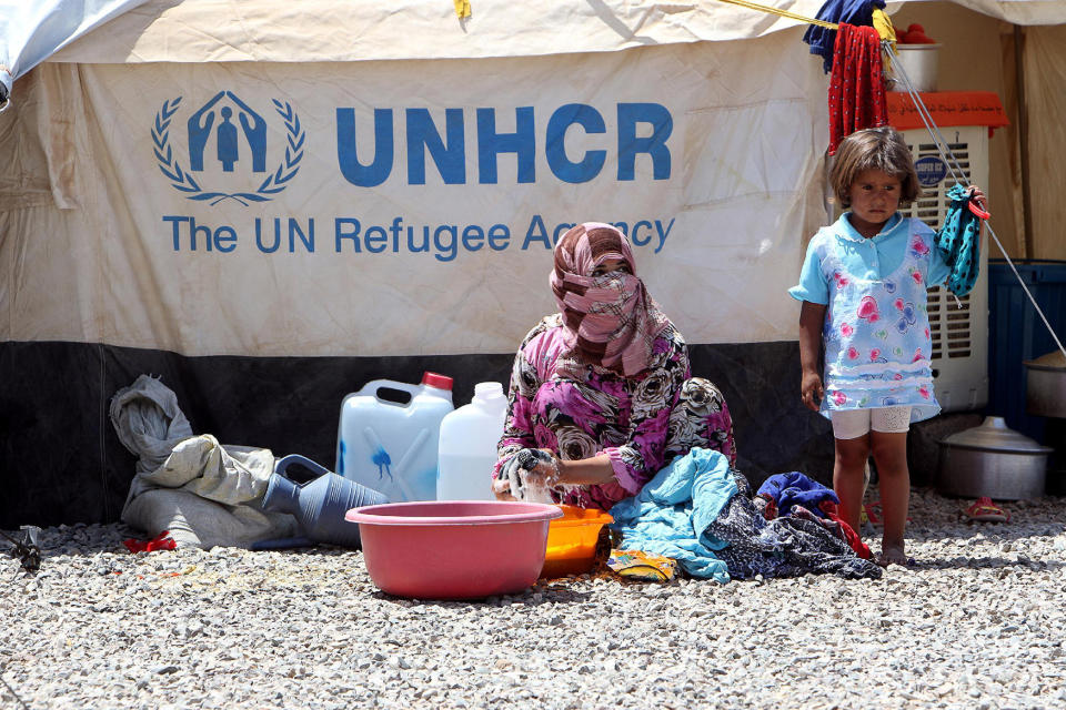 An Iraqi woman washes clothes at a refugee camp near Mosul