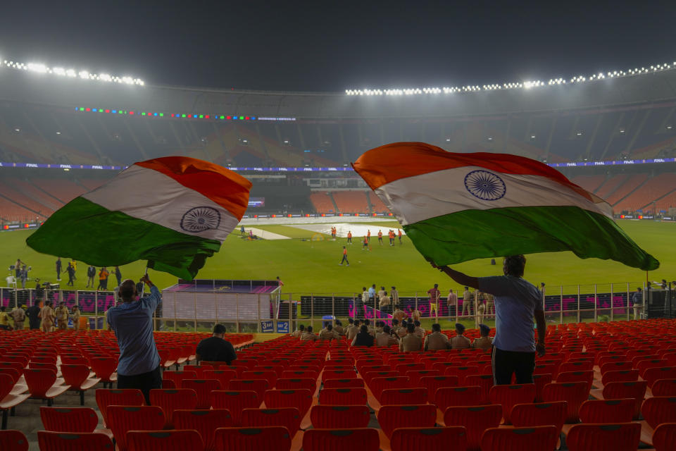 Indian fans wave flag as team India attends a training session ahead of the ICC Men's Cricket World Cup final match between India and Australia in Ahmedabad, India, Saturday, Nov. 18, 2023. (AP Photo/Mahesh Kumar A.)