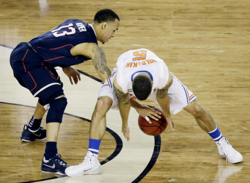 Connecticut guard Shabazz Napier (13) and Florida guard Scottie Wilbekin (5) reach for a loose ball during the second half of the NCAA Final Four tournament college basketball semifinal game Saturday, April 5, 2014, in Arlington, Texas. (AP Photo/Tony Gutierrez)