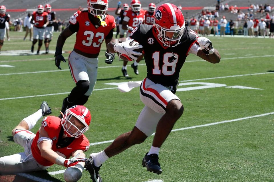 Georgia wide receiver Sacovie White (18) breaks away for a touchdown while Georgia defensive back Jake Pope (22) pulls off White's shoe during the G-Day spring football game in Athens, Ga., on Saturday, April 13, 2024. The game ended in a tie.