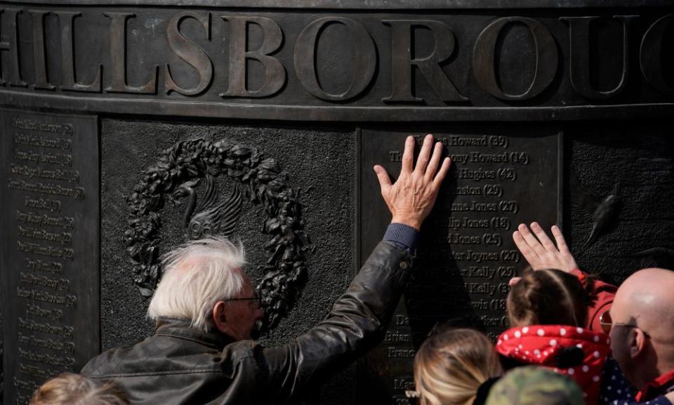 People place their hands on the Hillsborough memorial outside Liverpool’s Saint George’s Hall.