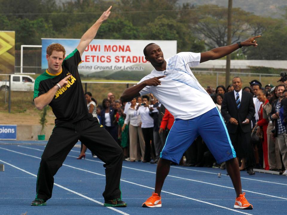 Prince Harry and Olympic gold medalist Usain Bolt pose on a running track in Jamaica