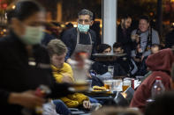 Waiters wearing masks serve food and drink in a terrace outside Mestalla stadium during the Champions League round of 16 second leg soccer match between Valencia and Atalanta in Valencia, Spain, Tuesday March 10, 2020. The match is being in an empty stadium because of the coronavirus outbreak. (AP Photo/Emilio Morenatti)