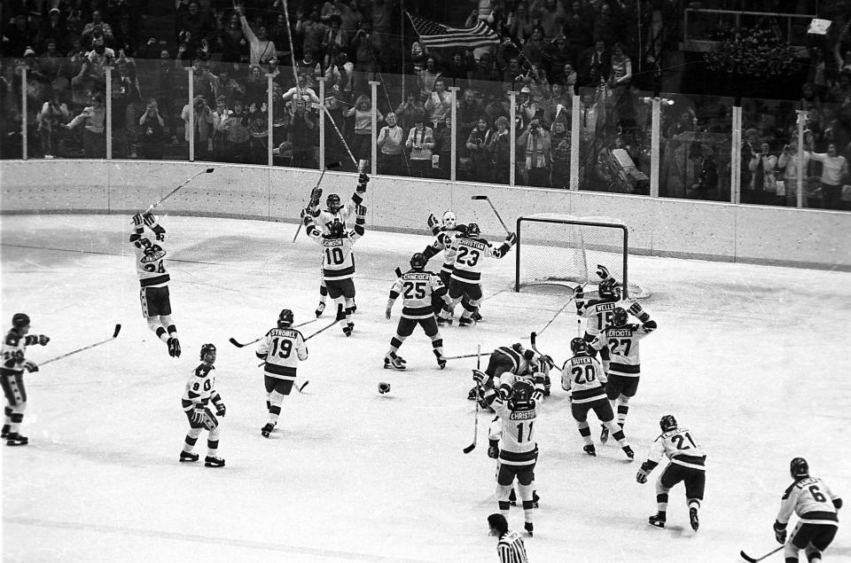 FILE - In this Feb. 22, 1980, file photo, the U.S. ice hockey team rushes toward goalie Jim Craig after their 4-3 upset win over the Soviet Union in a medal round match at the Winter Olympics in Lake Placid, N.Y. Some of the U.S. players shown are Mark Johnson (10); Eric Strobel (19); William Schneider (25); David Christian (23); Mark Wells (15); Steve Cristoff (11); Bob Suter (20) and Philip Verchota (27). (AP Photo/File)