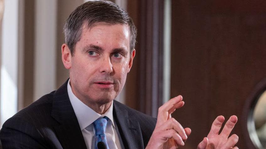 Dave Ricks, the boss of Eli Lilly, gesturing with his hands at a conference in March, wearing a dark suit and blue tie