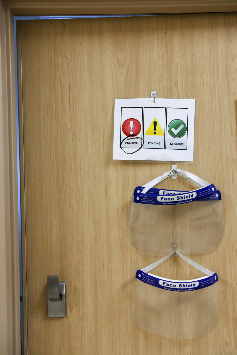 PPE and signs denoting the patient's status hang on each door next in the seventh floor COVID-19 unit at East Alabama Medical Center Thursday, Dec. 10, 2020, in Opelika, Ala. The medical center faces a new influx of COVID-19 patients as the pandemic intensifies. (AP Photo/Julie Bennett)