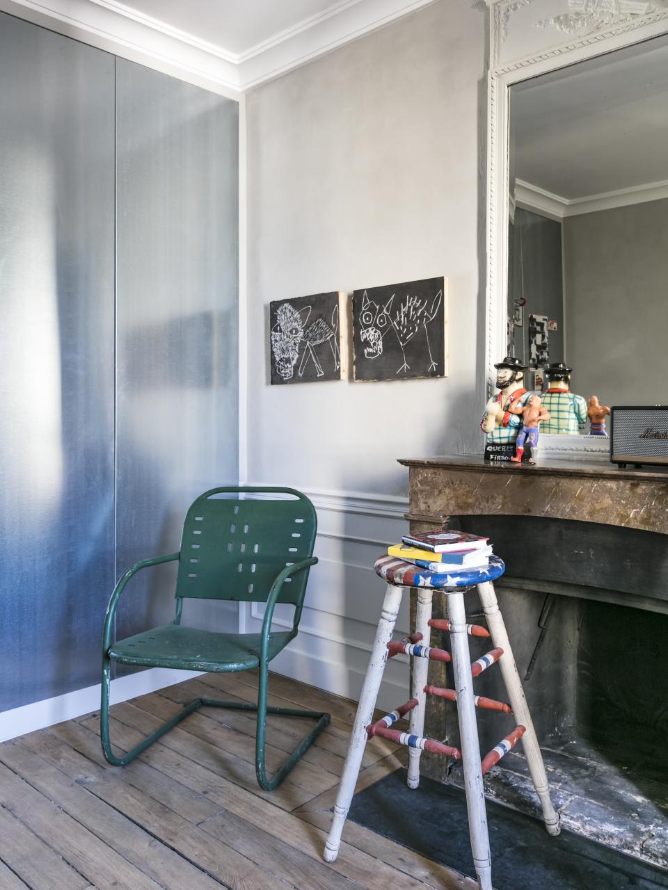 The Marshall speaker seen on the mantel is an example of a piece sold through Merci. Chalk and ink drawings on cardboard by Rochegaussen from School Gallery hang above a vintage American garden chair and barstool.