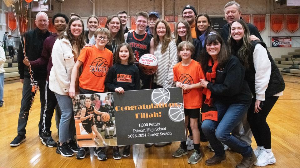 Pitman's Elijah Crispin is joined by family members for a photo after Crispin reached and surpassed his 1,000th career points milestone during Pitman's 71-60 victory over Salem at Pitman High School on Tuesday, January 23, 2024.