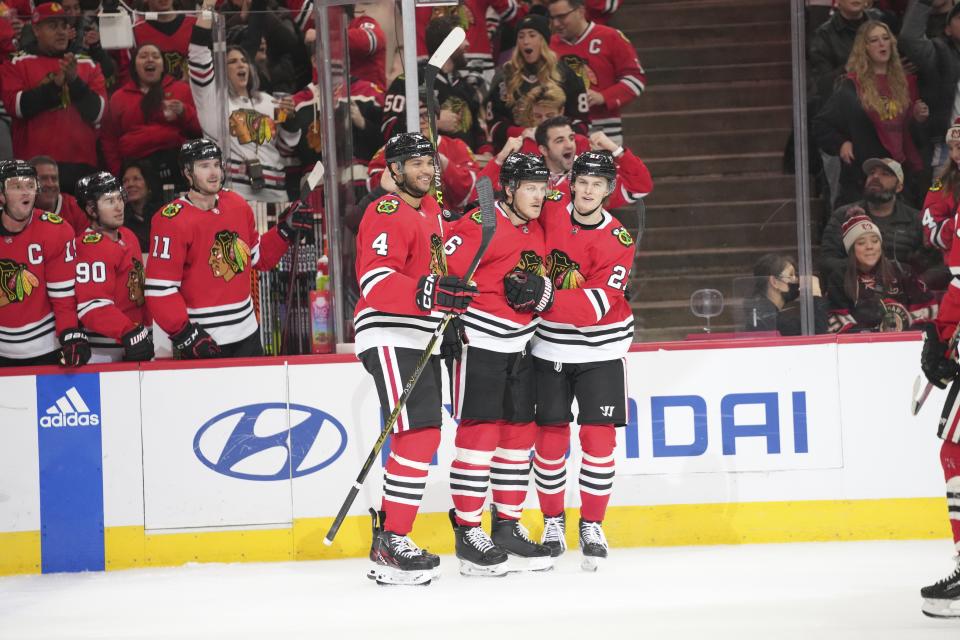 Chicago Blackhawks defenseman Seth Jones, left, and left wing Lukas Reichel, right, celebrate after a goal by defenseman Jake McCabe (6) during the second period of an NHL hockey game against the Arizona Coyotes, Friday, Jan. 6, 2023, in Chicago. (AP Photo/Erin Hooley)