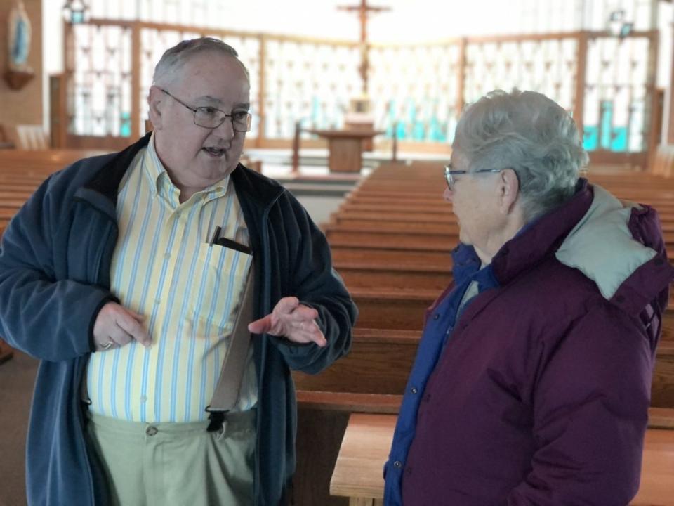 Glen Dowey, left, and Adele Demers chat inside Notre Dame Church in Springvale, Maine, on Monday, Jan. 30, 2023. On the approaching occasion of the church's final Mass on Feb. 11, 2023, Dowey and Demers shared both the history and their warmest memories of the church.