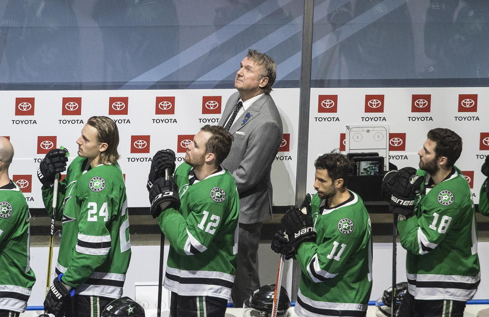 Dallas Stars head coach Rick Bowness looks up to Dale Hawerchuk as he is honored before NHL Western Conference Stanley Cup playoff action against the Calgary Flames, in Edmonton, Alberta, Tuesday, Aug. 18, 2020. (Jason Franson/The Canadian Press via AP)