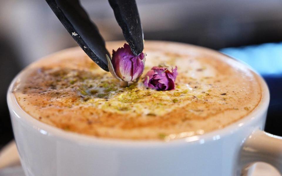 A second flower is added to a pistachio-flavored Pistaccino coffee drink at Zaatar Bistro, Friday, April 12, 2024 in Fresno.