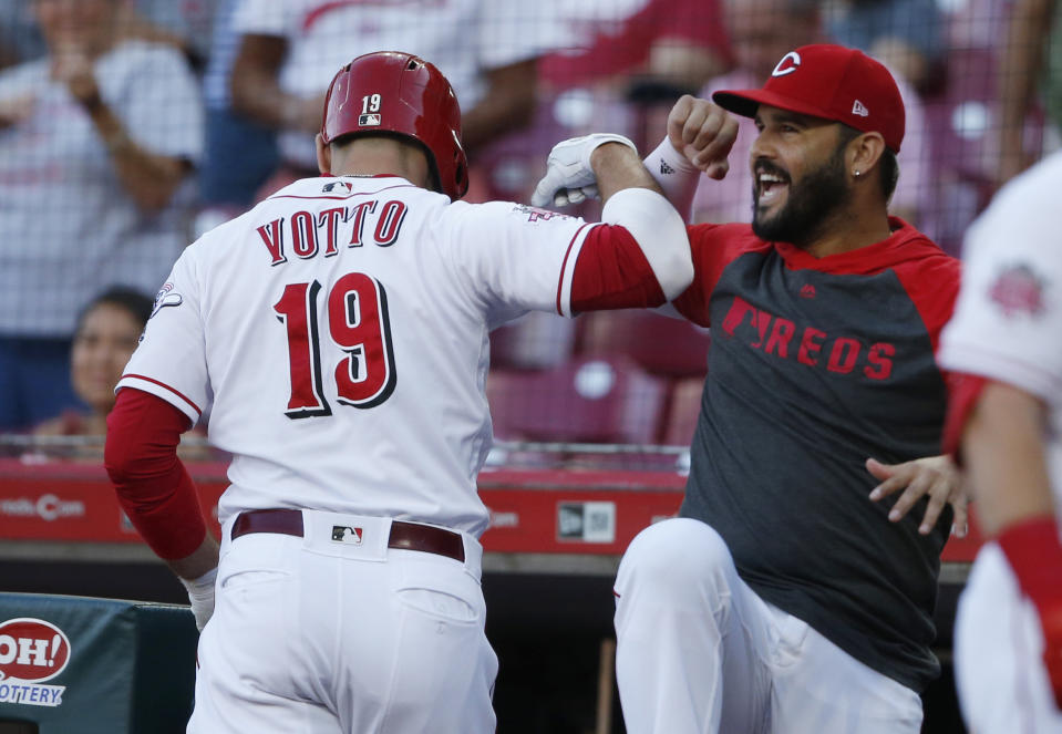 Cincinnati Reds' Joey Votto (19) is congratulated for his solo home run off Philadelphia Phillies starting pitcher Aaron Nola by Eugenio Suarez during the first inning of a baseball game Wednesday, Sept. 4, 2019, in Cincinnati. (AP Photo/Gary Landers)