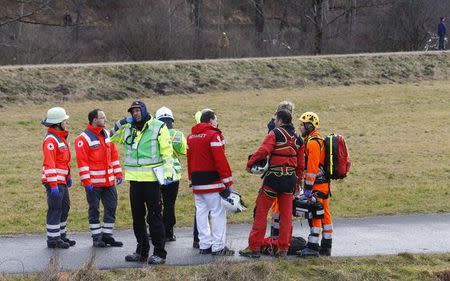 Members of rescue services stand on a road near Bad Aibling in southwestern Germany, February 9, 2016. REUTERS/Michael Dalder