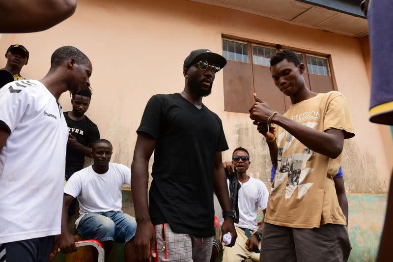 Sierra Leonean musician Emmerson Bockarie stands with a group of fans in his childhood neighborhood of Wilberforce in Freetown
