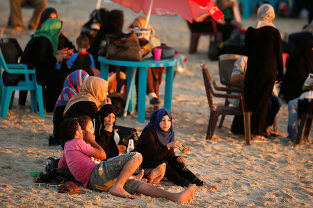 Palestinian family rests on a beach on a hot day in Gaza City. REUTERS/Suhaib Salem