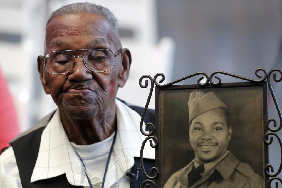 World War II veteran Lawrence Brooks holds a photo of him taken in 1943, as he celebrates his 110th birthday at the National World War II Museum in New Orleans, Thursday, Sept. 12, 2019. Brooks was born Sept. 12, 1909, and served in the predominantly African-American 91st Engineer Battalion, which was stationed in New Guinea and then the Philippines during World War II. He was a servant to three white officers in his battalion. (AP Photo/Gerald Herbert)