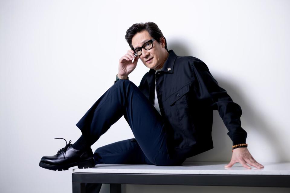 An actor in his trademark black glasses sits for a portrait.