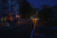 People walk along a road during a blackout in central Kyiv, Ukraine, Thursday, June 6, 2024. (AP Photo/Alex Babenko)