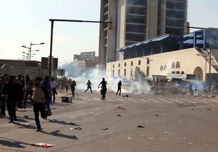 Protesters run from tear gas fired by security forces after supporters of Iraqi Shi'ite cleric Moqtada al-Sadr tried to approach the heavily fortified Green Zone during a protest at Tahrir Square in Baghdad, Iraq February 11, 2017. REUTERS /Mahmoud Raouf Mahmoud