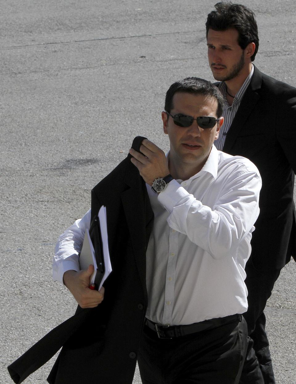 Head of Greece's radical left-wing Syriza party Alexis Tsipras arrives at Zappeio Conference Hall following his statement in Athens, Tuesday, June 12, 2012. Tsipras, whose party came a surprise second in inconclusive May 6 elections, said he would stick to his pledge to tear up Greece's bailout deal, saying the austerity the country has been forced to impose in return for billions of euros in rescue loans was leading Greece towards collapse. (AP Photo/Petros Karadjias)