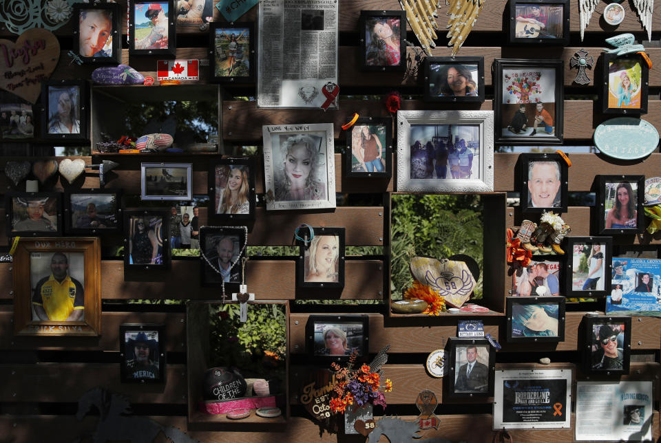 Photographs adorn a wall at a memorial garden for victims of a mass shooting in Las Vegas, Thursday, Oct. 3, 2019, in Las Vegas. Two years after a shooter rained gunfire on country music fans from a high-rise Las Vegas hotel, MGM Resorts International reached a settlement that could pay up to $800 million to families of the 58 people who died and hundreds of others who were injured, attorneys said Thursday. (AP Photo/John Locher)