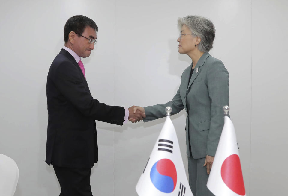 Japanese Foreign Minister Taro Kono, left, shakes hands with his South Korean counterpart Kang Kyung-wha prior to a bilateral meeting on the sidelines of the ASEAN Foreign Ministers Meetings in Bangkok, Thailand, Thursday, Aug. 1, 2019. (Lee Jung-hoon/Yonhap via AP)