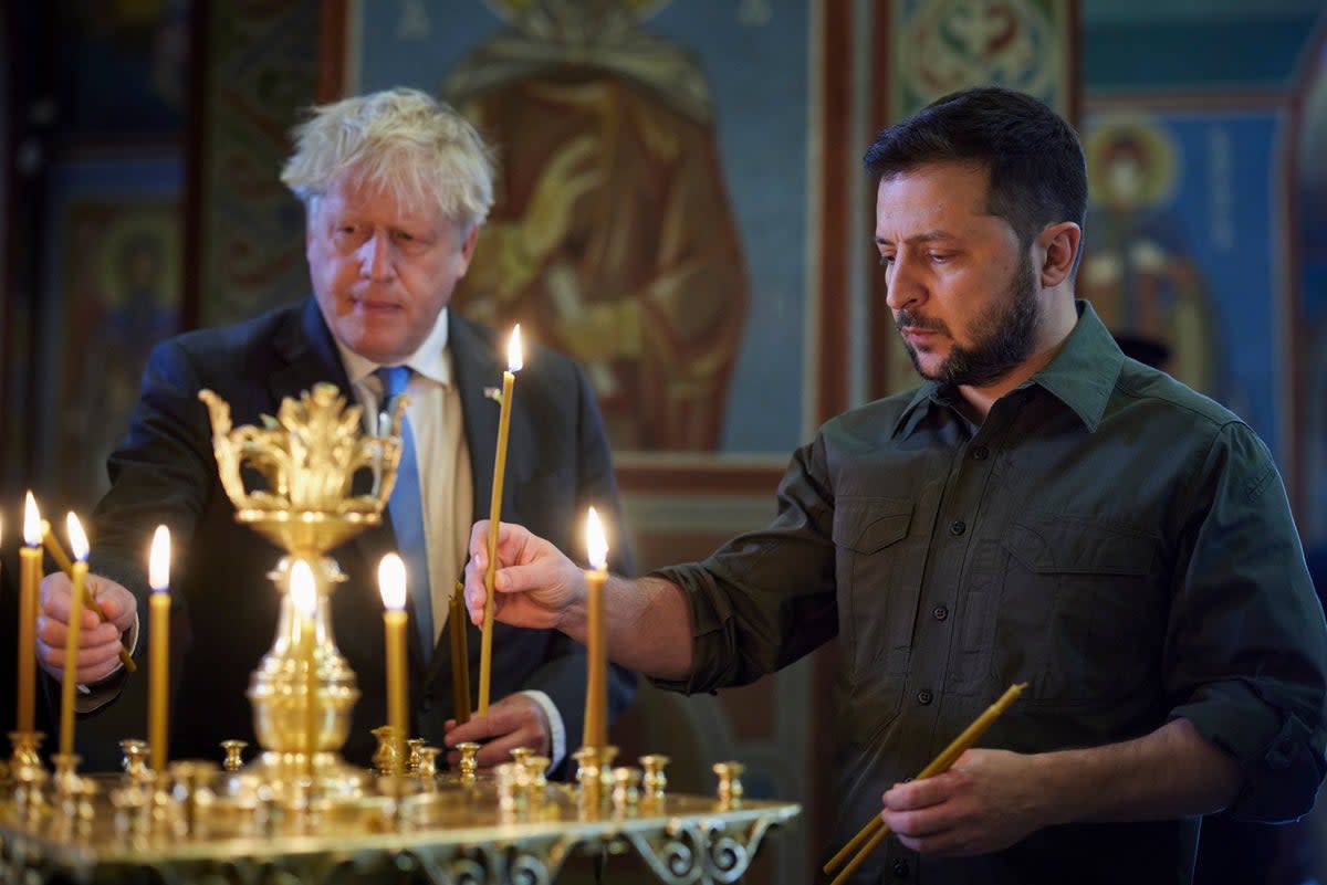 Boris Johnson and Volodymyr Zelensky lighting candles at the St. Mikhailovsky Cathedral in Kyiv last month (EPA)