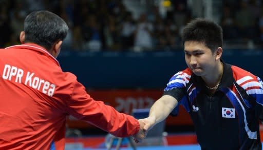 South Korea's Ryu Seung-Min (right) shakes hands with North Korea's coach after defeating Kim Hyok Bong of North Korea in a table tennis match at the Excel centre in London