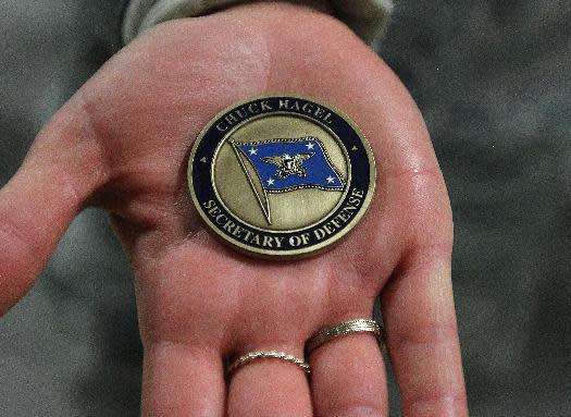 Lt. Christen Ornella holds out a military coin that were handed out to airmen attending the visit of Defense Secretary Chuck Hagel on Thursday, Jan. 9, 2014 at F.E. Warren Air Force Base in Cheyenne, Wyo. It was the first time since 1982 that a defense secretary has visited the nuclear missile base. (AP Photo/Wyoming Tribune Eagle, Blaine McCartney)