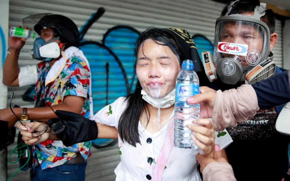 A demonstrator gets assistance during a protest against the Thai government's handling of the pandemic in Bangkok, Thailand on 13 August 2021 - Soe Zeya Tun/Reuters