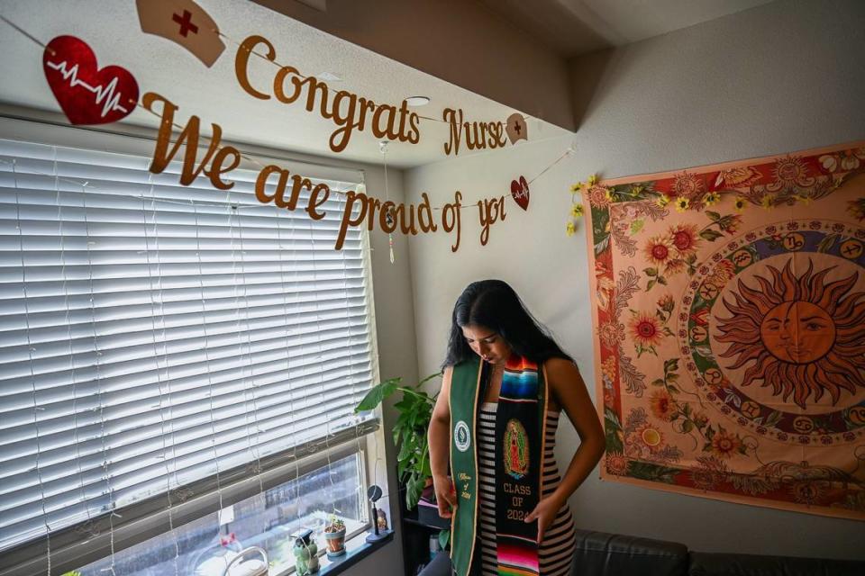 Perla Valdovinos Galvan contemplates which stole to wear for her pinning ceremony and graduation from the school of nursing in her dorm at Sacramento State on May 16. ”People are there, people want to help you, and that is how I overcame my challenges,” she said.