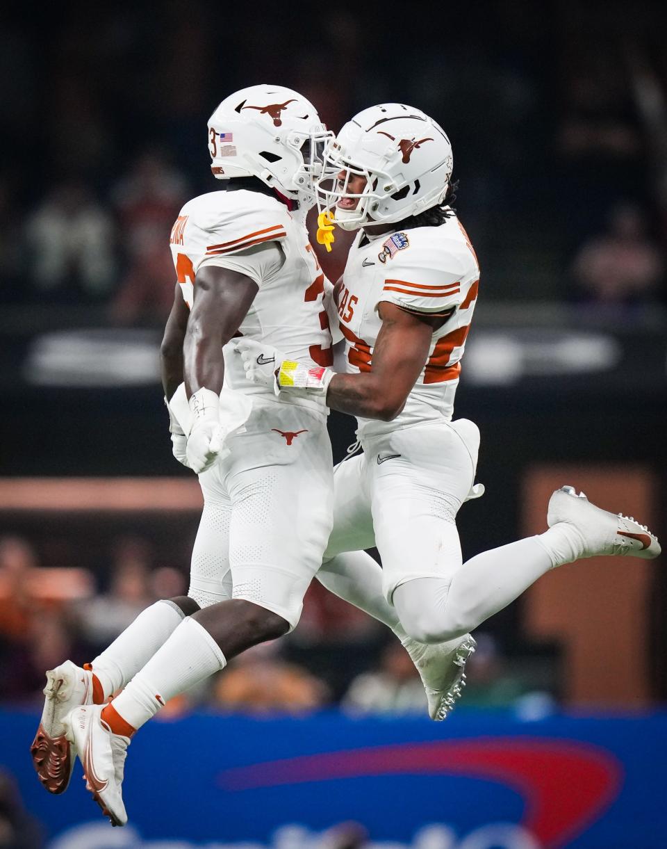 Texas linebacker David Gbenda, left, and defensive back Jahdae Barron celebrate a play during the Jan. 1 Sugar Bowl loss to Washington in the CFP semifinals. Both Longhorns are key returners to this year's defense.