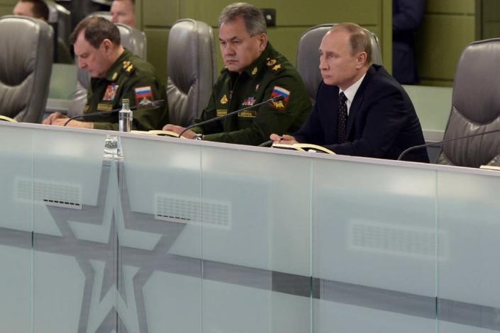 Russian President Vladimir Putin (R), accompanied by Defence Minister Sergei Shoigu (C), meets with top military officials at the National Defence Control Centre of the Russian Federation in Moscow on November 17, 2015 (AFP Photo/Alexei Nikolsky)