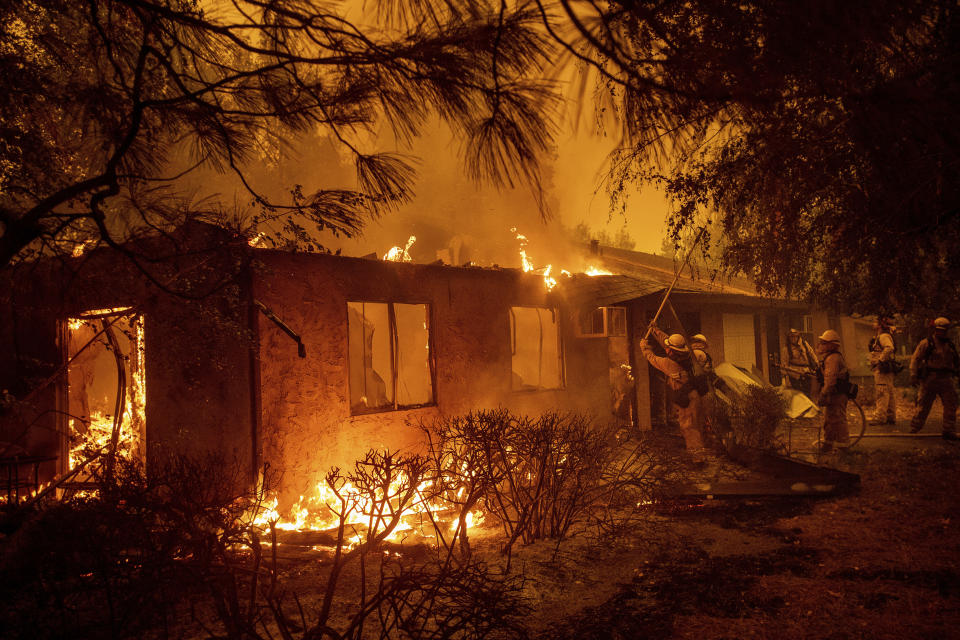 Firefighters work to keep flames from spreading through the Shadowbrook apartment complex as a wildfire burns through Paradise, Calif., on Friday, Nov. 9, 2018. (AP Photo/Noah Berger)