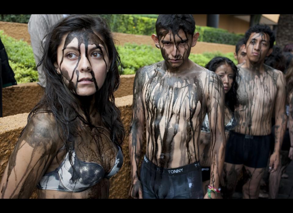 Members of AnimaNaturalis with their bodies covered with black paint protest against the oil spill of BP's drilling well in the Gulf of Mexico, on July 22, 2010 in Mexico city. Demostrators aim to alert people about the animals dying because of the oil spill and call to use less petrol.  AFP PHOTO/ Omar TORRES (Photo credit should read OMAR TORRES/AFP/Getty Images)