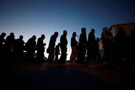 Palestinians working in Israel stand in line as they wait to cross through Israeli Qalandiya checkpoint near the West Bank city of Ramallah April 25, 2017. REUTERS/Mohamad Torokman