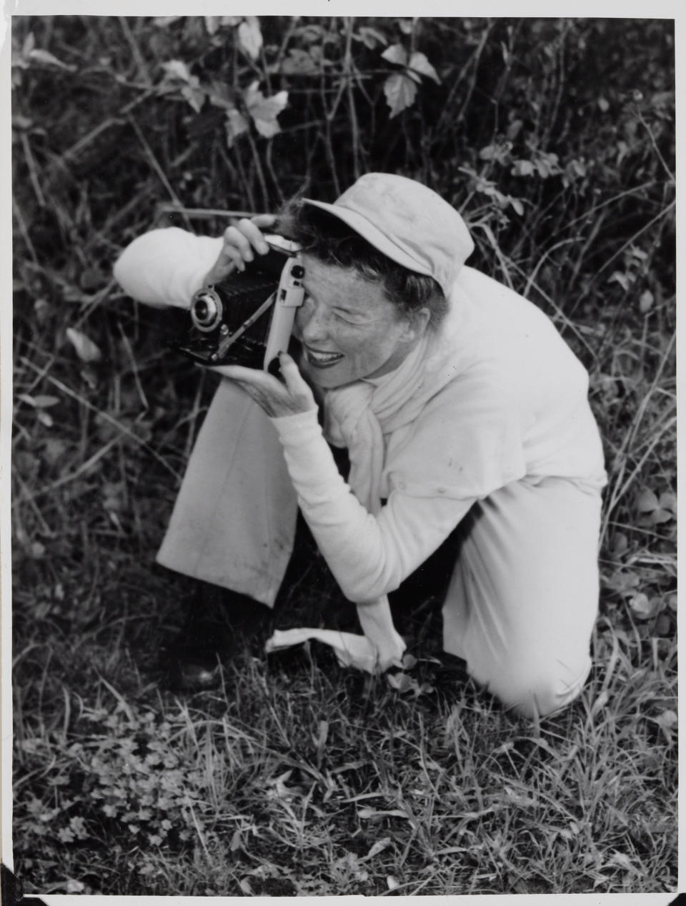FILE - This picture provided by The New York Public Library shows Katherine Hepburn taking a picture in a photo from her scrapbook of her 1955 Old Vic Australian tour. "The fact that she wore slacks and wanted to be comfortable influenced women's ready-to-wear in the United States," said Jean Druesedow, director of the Kent State University Museum, which was given 700 items from Hepburn’s estate. (AP Photo/The New York Public Library)