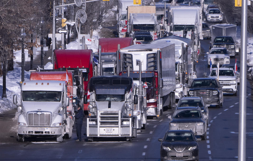 Vehicles from the protest convoy are parked blocking lanes on a road, Sunday, Jan. 30, 2022 in Ottawa. Residents of the national capital are again being told to avoid traveling downtown as a convoy of trucks and cars snarl traffic protesting government-imposed vaccine mandates and COVID-19 restrictions. (Adrian Wyld/The Canadian Press via AP)