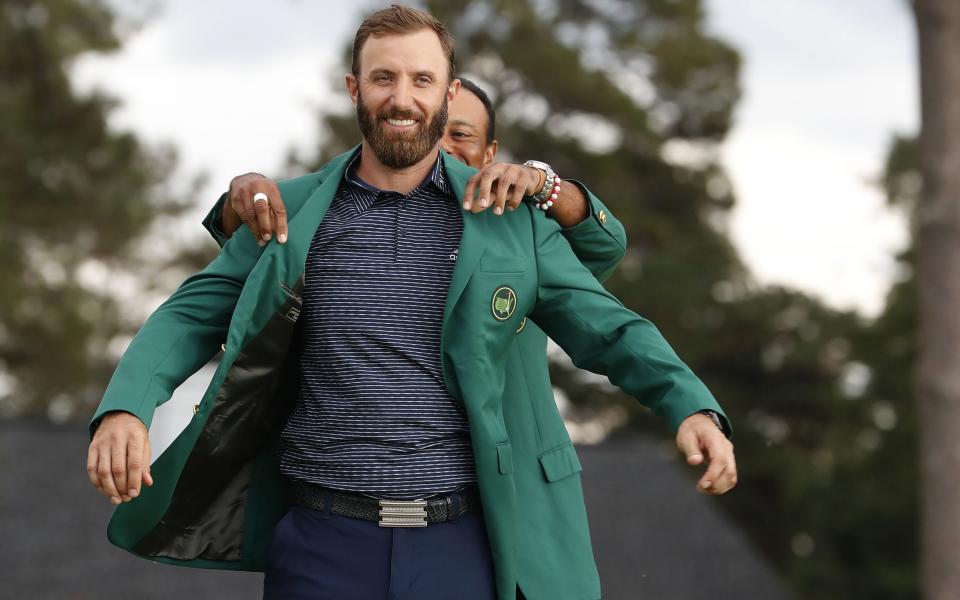 Dustin Johnson of the US (L) is presented his green jacket by defending champion Tiger Woods - Shutterstock