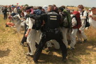 Numerous environmental activists walk on a roadway on the site of the Garzweiler open-cast mine in Garzweiler, Germany, Saturday, June 22, 2019. The protests for more climate protection in the Rhineland continue. (David Young/dpa via AP)