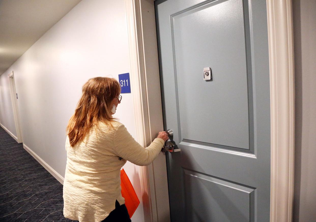 Champlin Place resident Kathy Giberson opens her apartment door at the new Easterseals affordable living complex in Rochester.